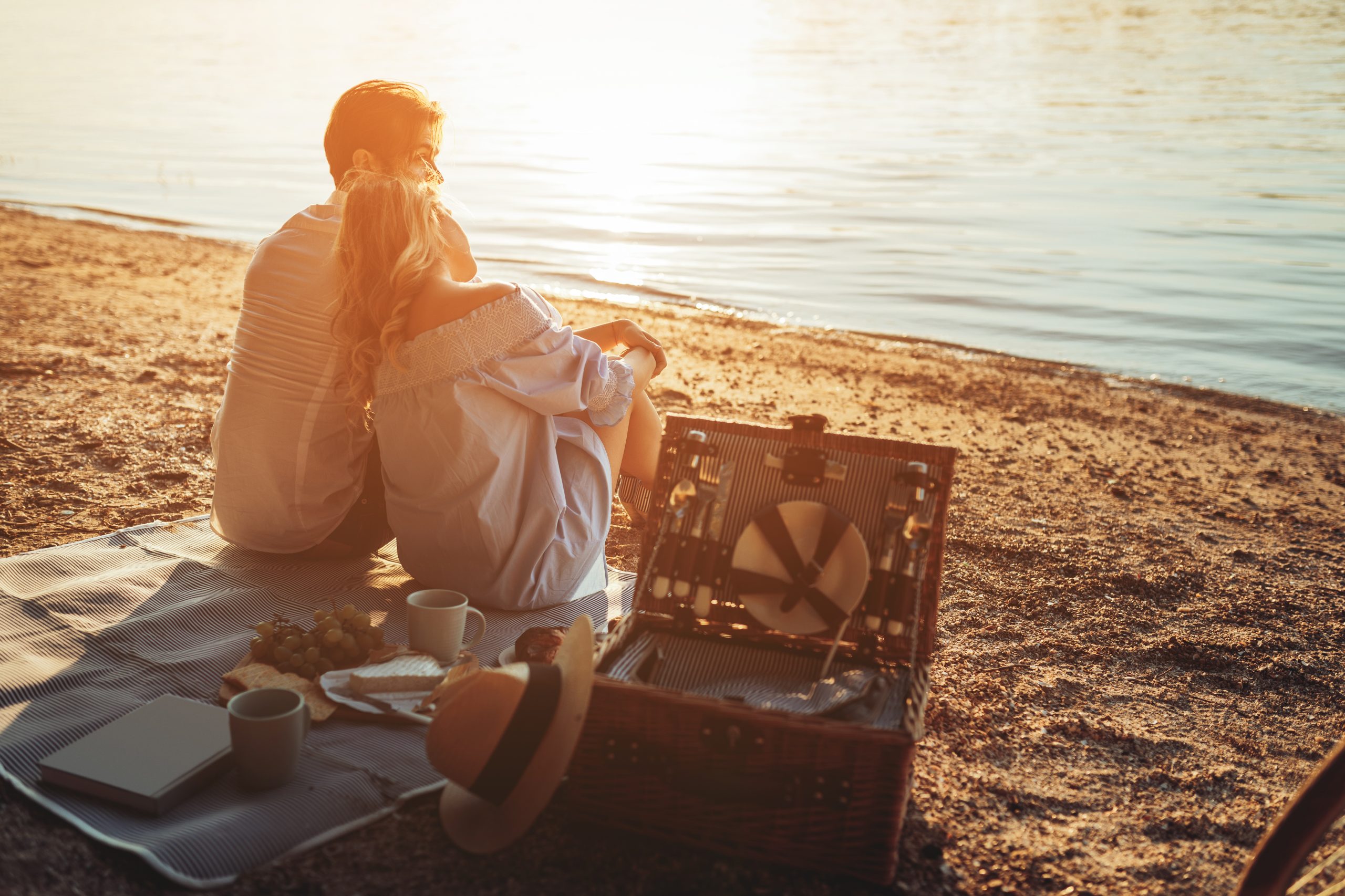 A,Young,Couple,Having,A,Picnic,At,The,Beach